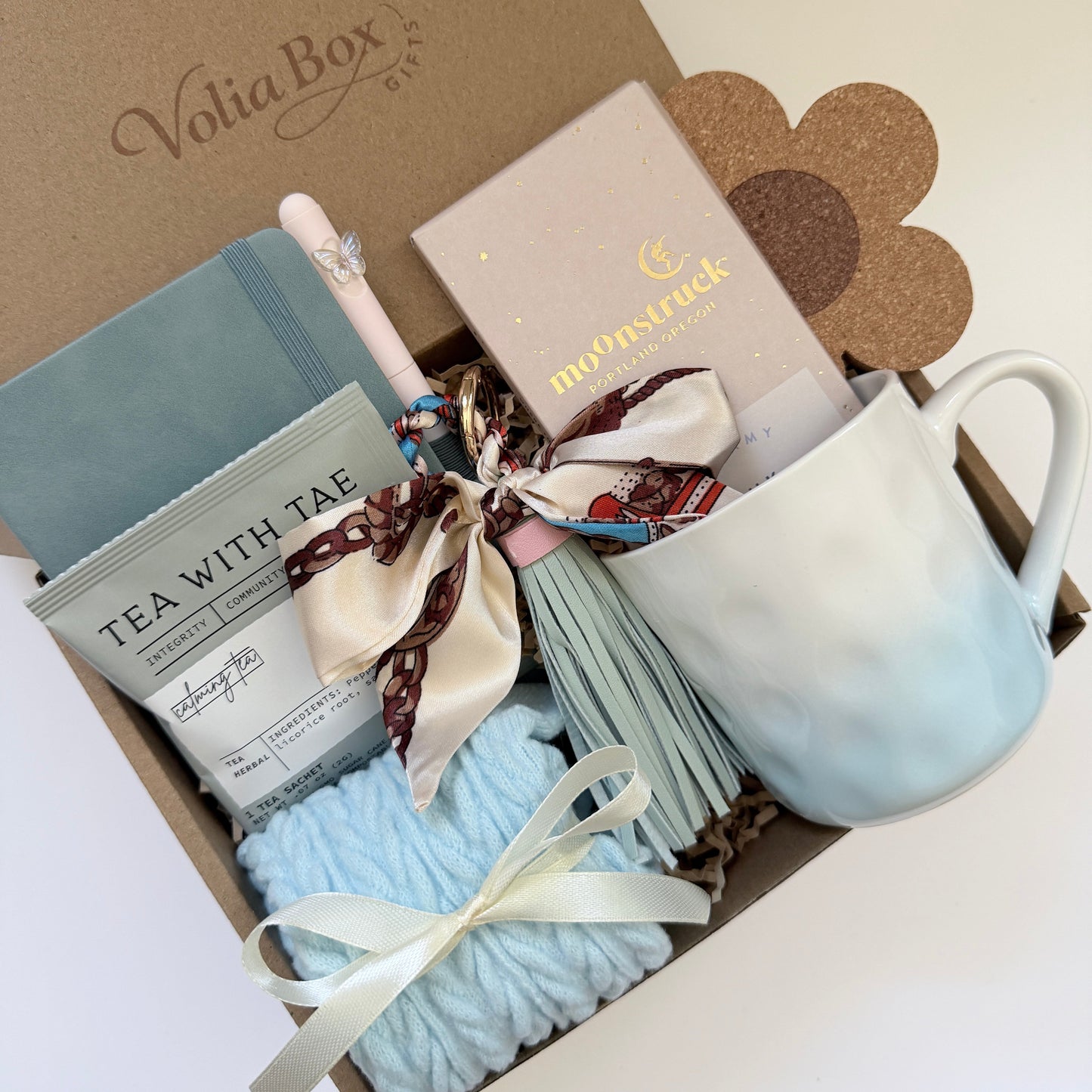 Self care gift set flat lay with notebook, socks, tea and chocolate