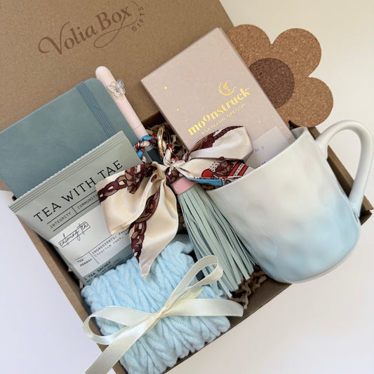 Self care gift set flat lay with notebook, socks, tea and chocolate