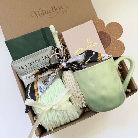Self care gift set flat lay with notebook, socks, tea and chocolate