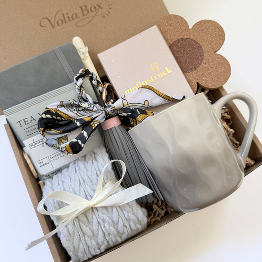 Self care gift set flat lay with notebook, socks, tea and chocolate